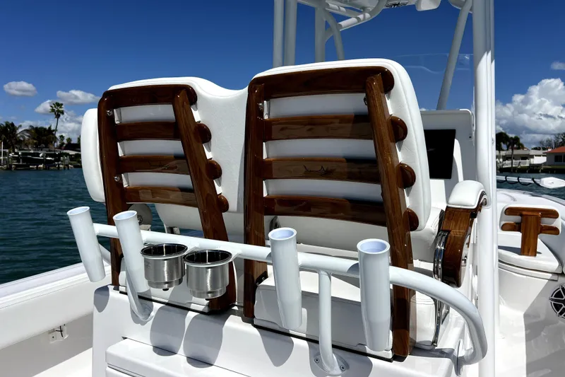 Slide: The Image of 2026 Contender 26 Bay boat seats with rod holders and cup holders, on a sunny day. - 32