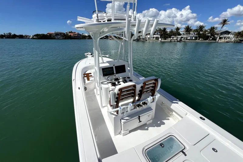 Slide: The Image of 2026 Contender 26 Bay boat on calm water, featuring a sleek design and modern console. - 35
