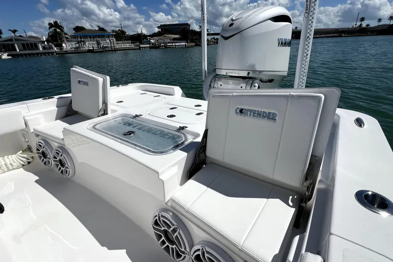 Slide: The Image of 2026 Contender 26 Bay boat interior with Yamaha engine, featuring seating and storage, docked by the water. - 38