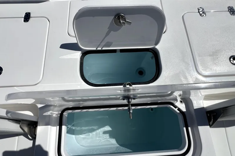 Slide: The Image of Contender 26 Bay 2026 boat storage compartments with open lids and secure locks. - 41