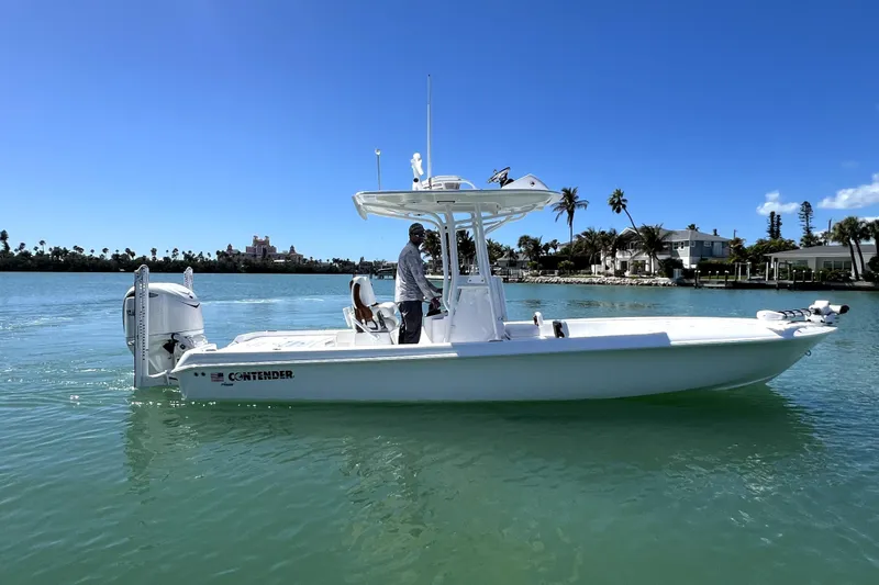 Slide: The Image of 2026 Contender 26 Bay boat on calm water, clear sky, palm trees in background. - 8