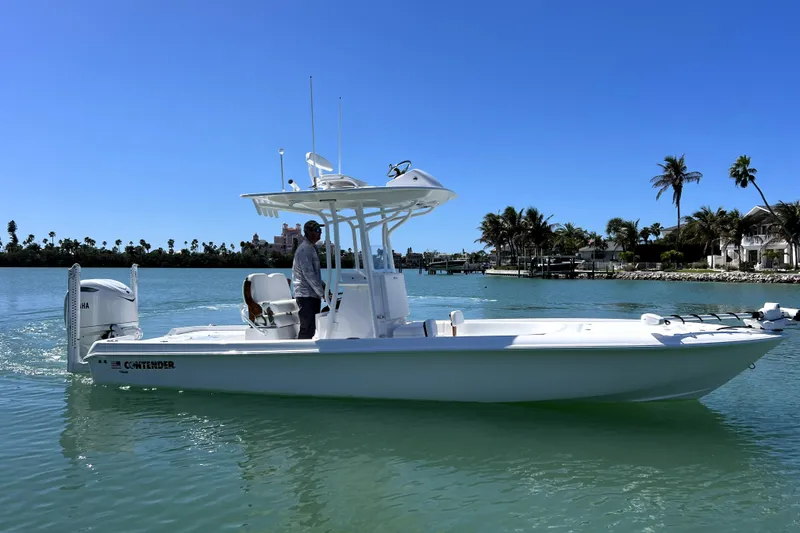 Slide: The Image of 2026 Contender 26 Bay boat cruising on a sunny day with palm trees in the background. - 9