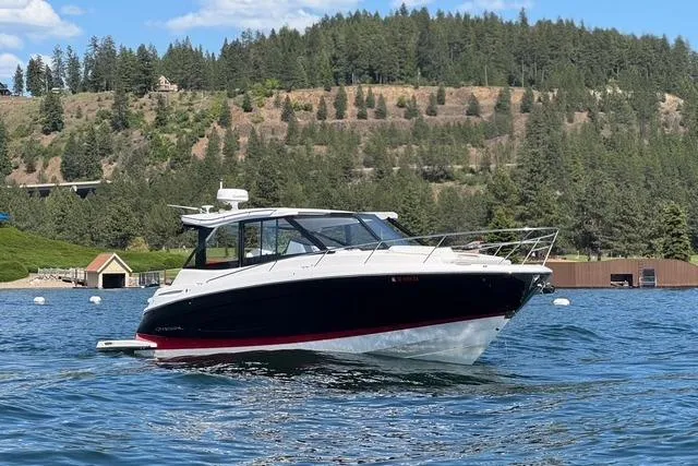 The Image of 2021 Regal 36 Grande Coupe on scenic lake with forested hills in background. - 0