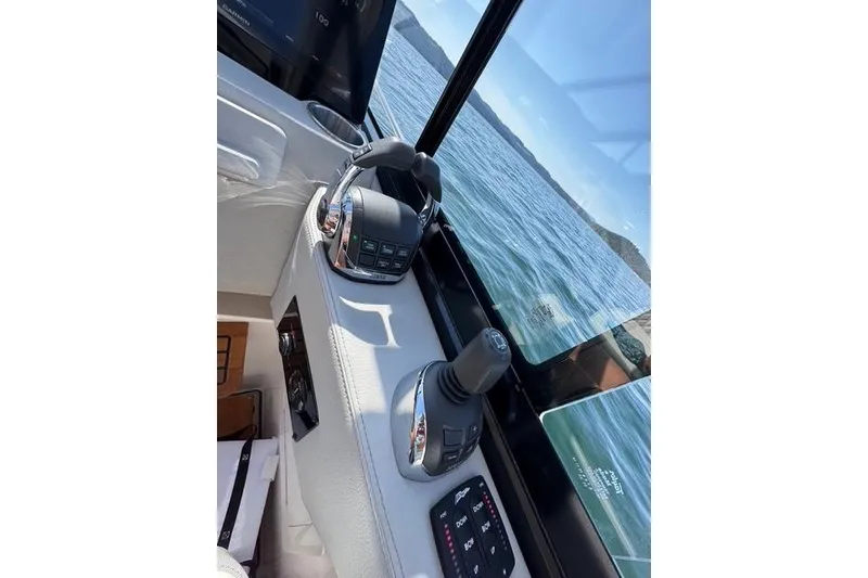 Slide: The Image of Cockpit controls of a 2021 Regal 36 Grande Coupe with scenic water view. - 2