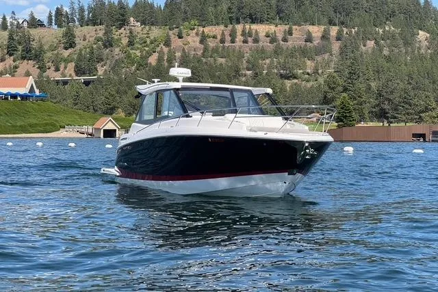 Slide: The Image of 2021 Regal 36 Grande Coupe on a scenic lake with forested hills. - 23