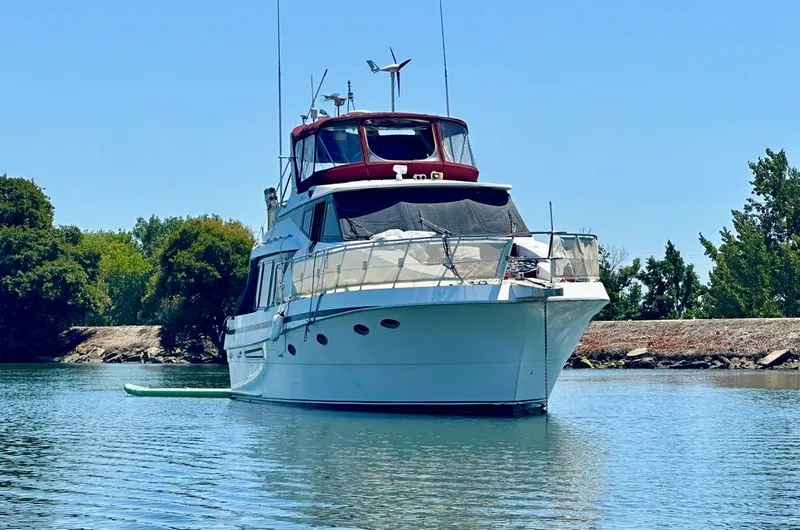 Slide: The Image of 1997 McKinna 48 Pilothouse yacht on calm water, surrounded by trees. - 1