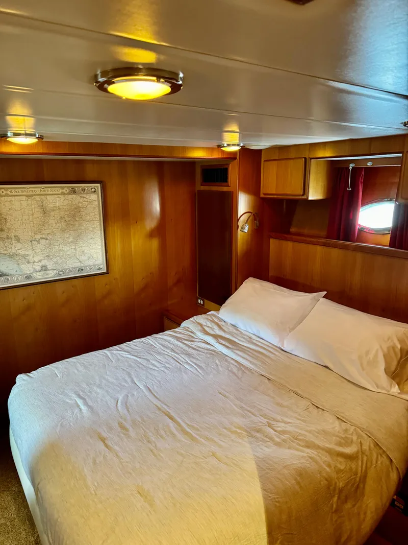 Slide: The Image of Cozy bedroom in 1997 McKinna 48 Pilothouse yacht with wood paneling and map decor. - 25