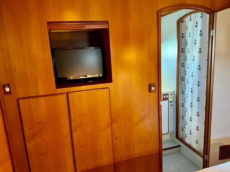 Slide: The Image of Interior of 1997 McKinna 48 Pilothouse with wood paneling and nautical-themed bathroom door. - 26