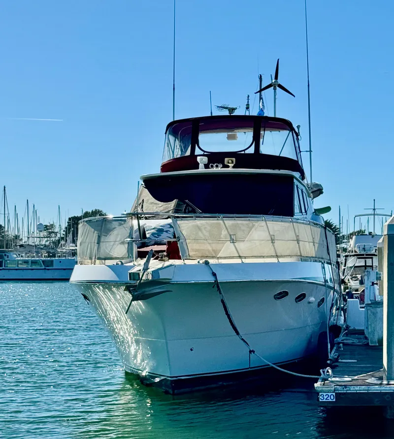 Slide: The Image of 1997 McKinna 48 Pilothouse yacht docked in a marina under clear blue skies. - 3