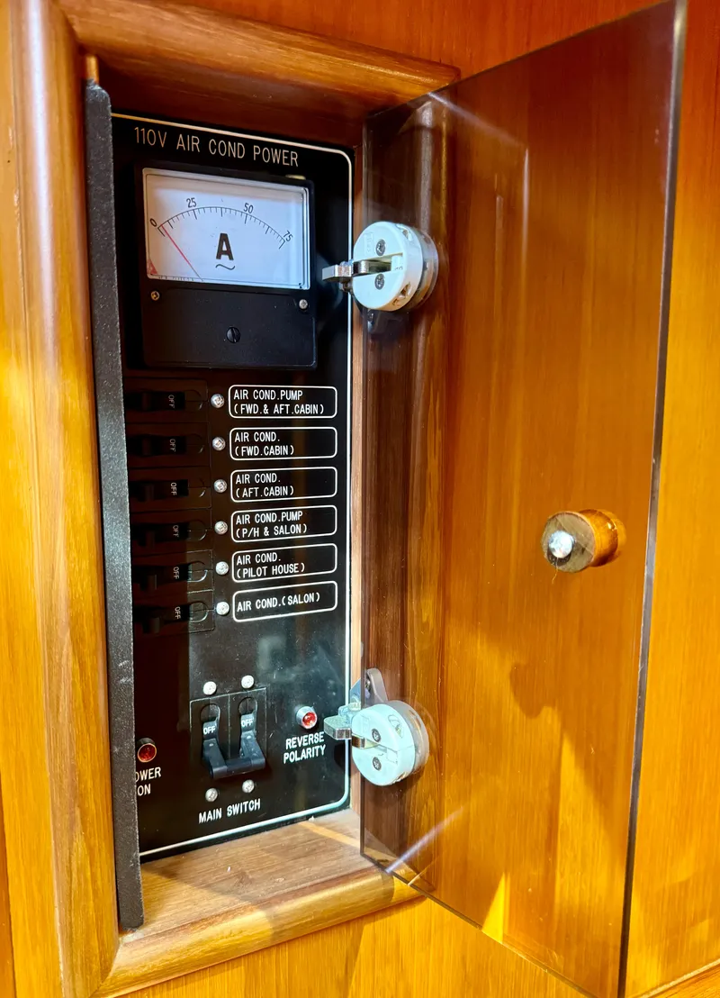 Slide: The Image of Electrical panel of a 1997 McKinna 48 Pilothouse yacht, featuring 110V air conditioning controls. - 34