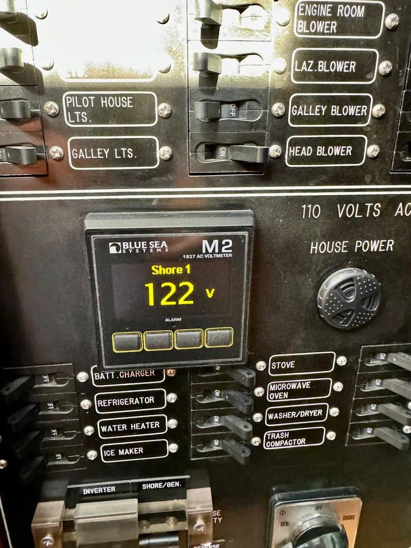 Slide: The Image of Electrical panel of a 1997 McKinna 48 Pilothouse yacht showing voltage and switches. - 46