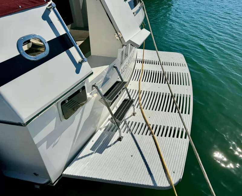 Slide: The Image of 1997 McKinna 48 Pilothouse yacht with swim platform, docked on calm water. - 5