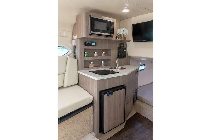 Slide: The Image of Manufacturer Provided Image: Compact kitchen area in 2026 Regal 26 XO boat with microwave, sink, and mini-fridge. - 13
