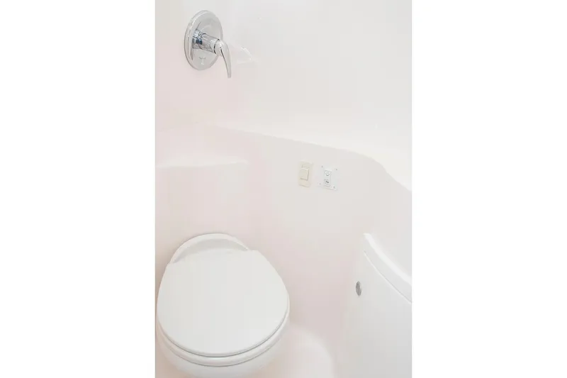 Slide: The Image of Manufacturer Provided Image: 2026 Regal 26 XO boat bathroom with white toilet and chrome fixtures. - 15