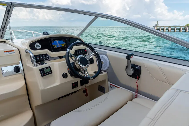 Slide: The Image of Manufacturer Provided Image: 2026 Regal 26 XO boat cockpit with steering wheel and control panel, ocean view. - 6
