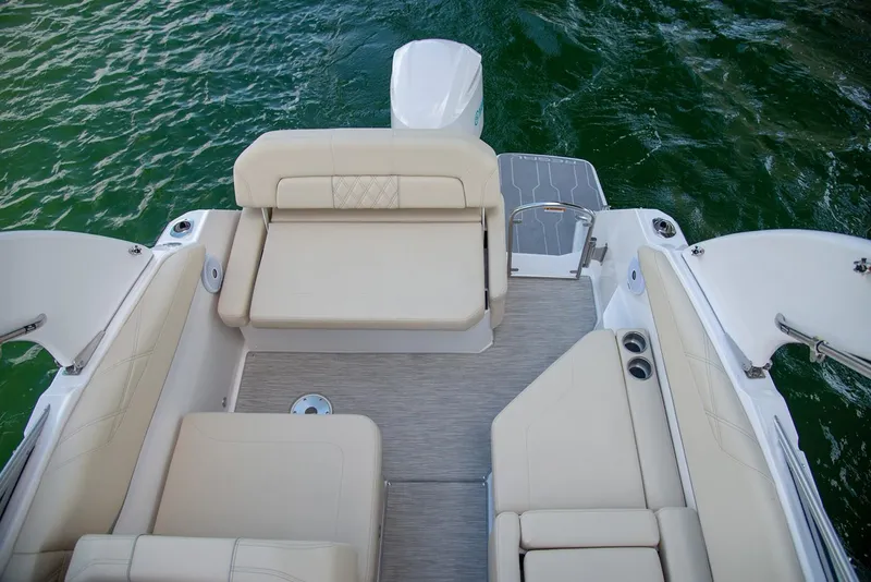 Slide: The Image of Manufacturer Provided Image: 2026 Regal 26 XO boat interior with beige seating, overlooking green water. - 8