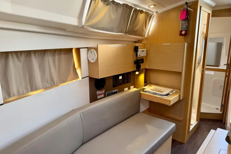 Slide: The Image of 2018 Beneteau Oceanis 35.1 interior with modern wood finish and cozy seating area. - 13