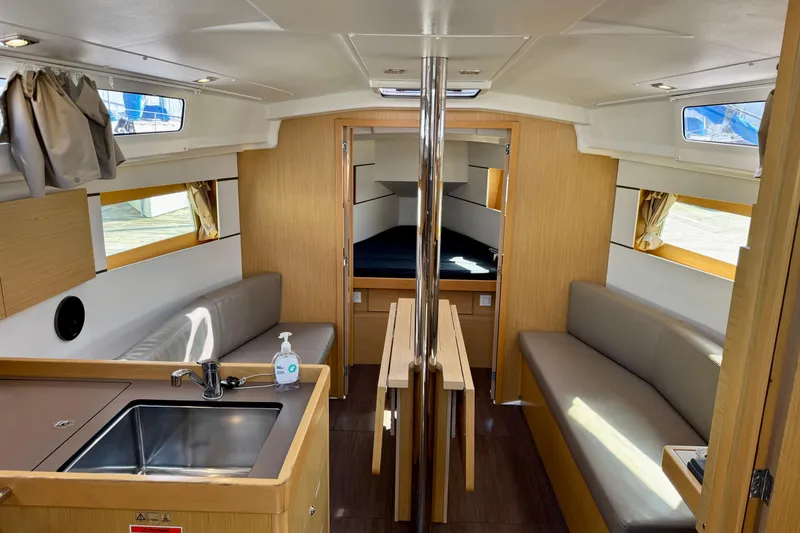 Slide: The Image of 2018 Beneteau Oceanis 35.1 interior with modern kitchen, seating, and cozy cabin space. - 14