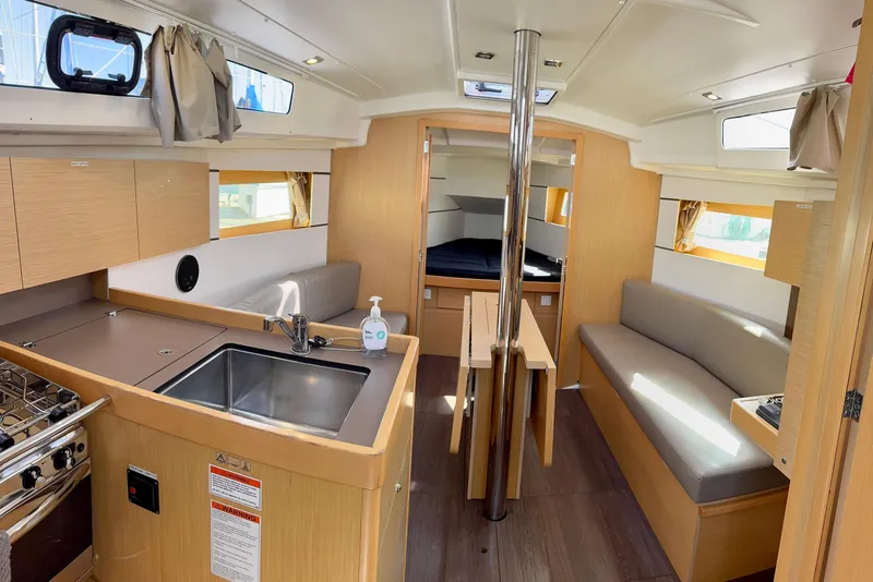 Slide: The Image of Interior of 2018 Beneteau Oceanis 35.1 sailboat, featuring modern kitchen and cozy seating area. - 17