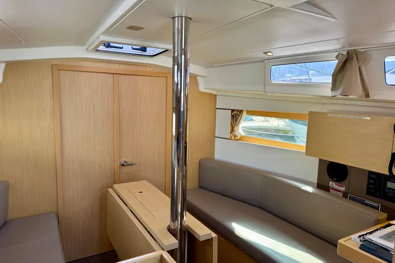Slide: The Image of Interior of 2018 Beneteau Oceanis 35.1 yacht, featuring modern wood finish and seating area. - 21