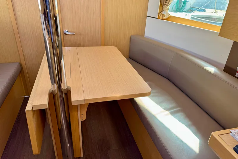 Slide: The Image of Interior of 2018 Beneteau Oceanis 35.1 yacht with wooden table and cushioned seating. - 22