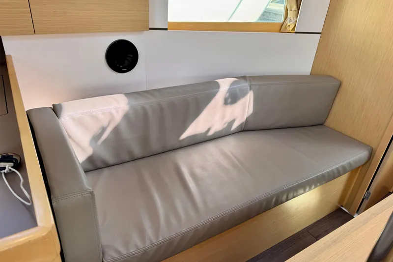 Slide: The Image of Interior of 2018 Beneteau Oceanis 35.1 yacht with a sleek, modern gray sofa. - 25