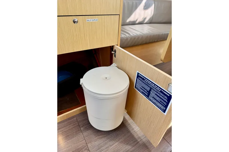 Slide: The Image of Open cabinet with trash bin in 2018 Beneteau Oceanis 35.1 galley area. - 43