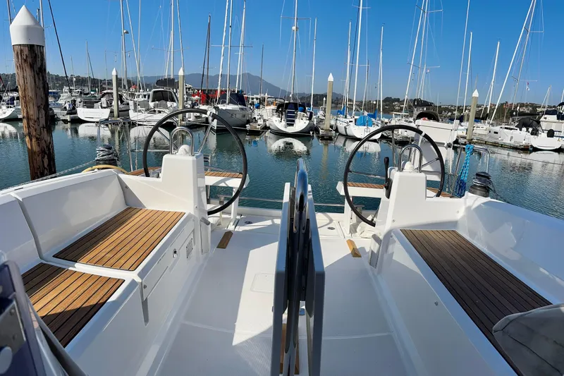 Slide: The Image of 2018 Beneteau Oceanis 35.1 sailboat docked in a marina, featuring dual steering wheels. - 45