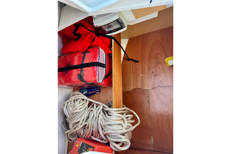 Slide: The Image of Storage compartment in a 2018 Beneteau Oceanis 35.1 with life jackets and coiled rope. - 53