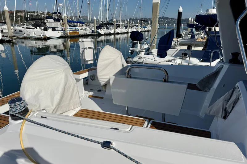 Slide: The Image of 2018 Beneteau Oceanis 35.1 sailboat docked in a marina, featuring covered equipment. - 60
