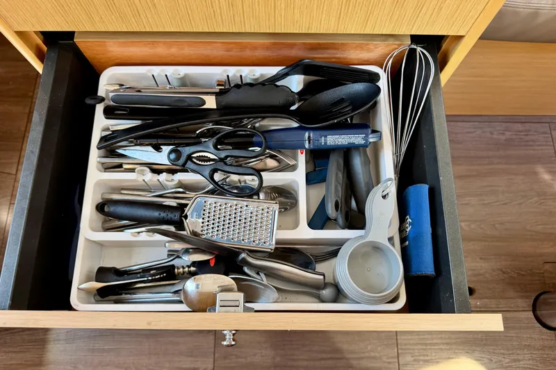 Slide: The Image of Kitchen drawer with assorted utensils on a 2018 Beneteau Oceanis 35.1 yacht. - 62