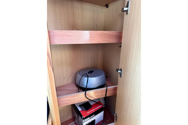 Slide: The Image of Open wooden cabinet in a 2018 Beneteau Oceanis 35.1 yacht interior. - 64