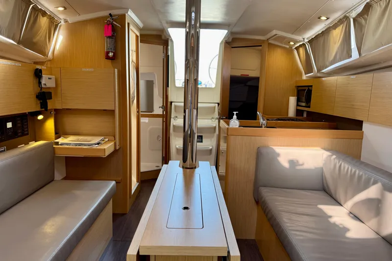 Slide: The Image of Interior of 2018 Beneteau Oceanis 35.1 yacht, featuring modern wood finish and cozy seating. - 8