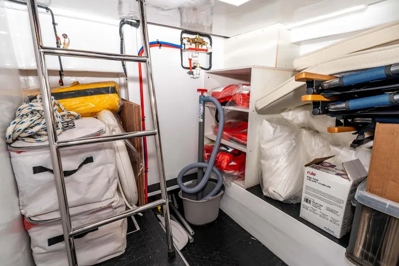 Slide: The Image of Storage area in 2021 Outback Yachts 50, featuring equipment, supplies, and a ladder. - 26
