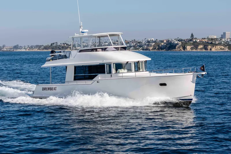 Slide: The Image of 2021 Outback Yachts 50 cruising on the ocean near a scenic coastline. - 29