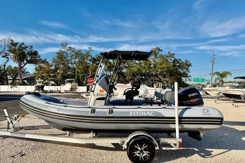 The Image of 2019 Zodiac Open 5.5 boat on trailer, parked outdoors under clear blue sky. - 0
