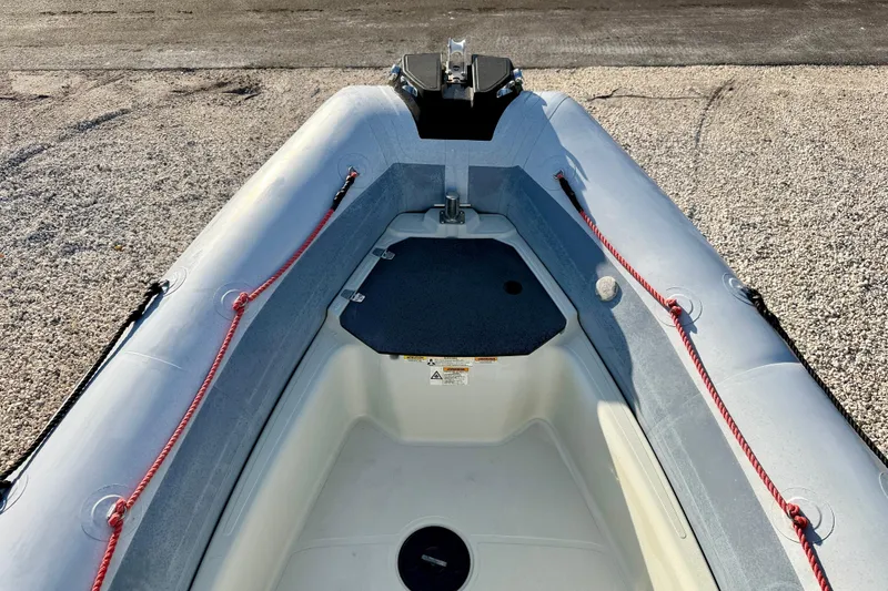 Slide: The Image of 2019 Zodiac Open 5.5 inflatable boat interior with red ropes and storage compartment. - 19