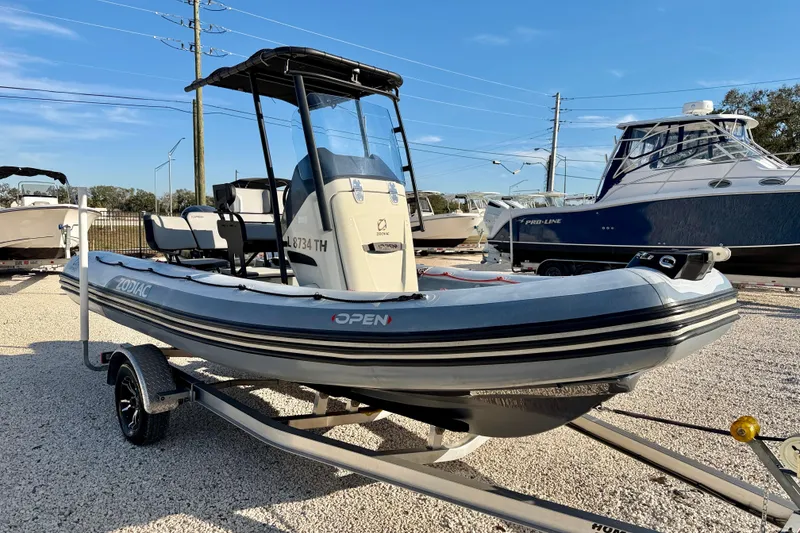 Slide: The Image of 2019 Zodiac Open 5.5 boat on trailer in a marina setting. - 4