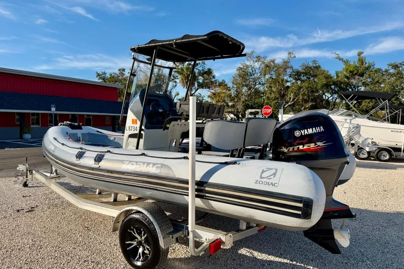 Slide: The Image of 2019 Zodiac Open 5.5 boat with Yamaha engine on trailer, parked outdoors. - 5