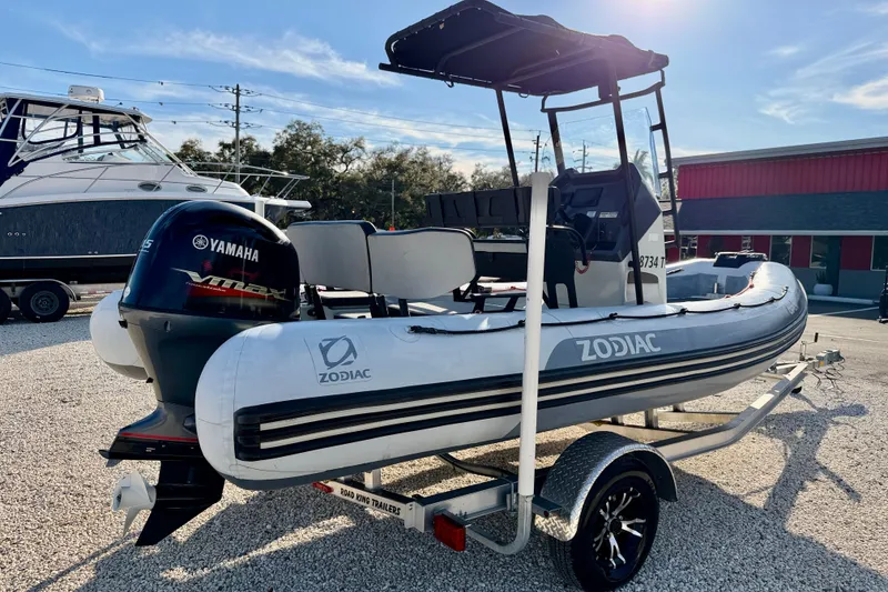 Slide: The Image of 2019 Zodiac Open 5.5 boat on trailer with Yamaha engine, parked outdoors. - 7