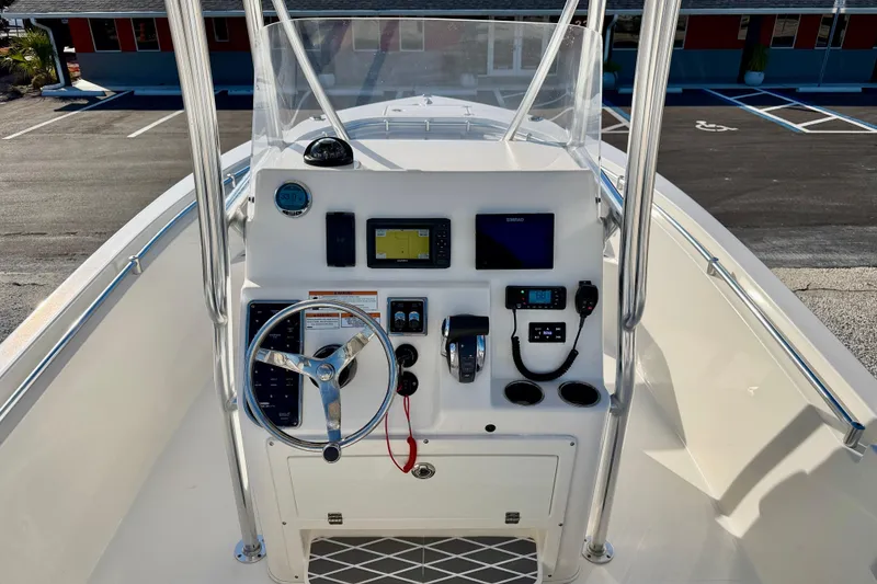 Slide: The Image of 2021 Cobia 237 Center Console boat dashboard with steering wheel and navigation controls. - 11