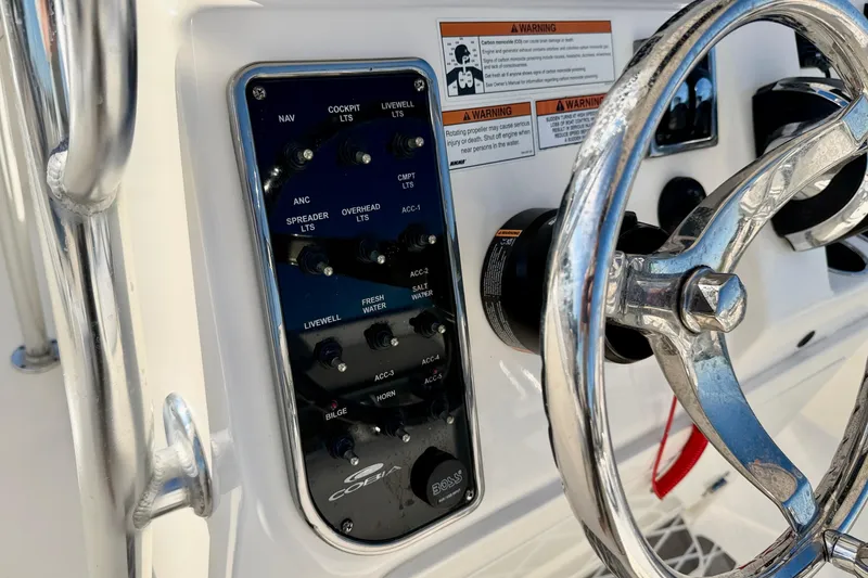 Slide: The Image of 2021 Cobia 237 Center Console dashboard with steering wheel and control panel. - 12