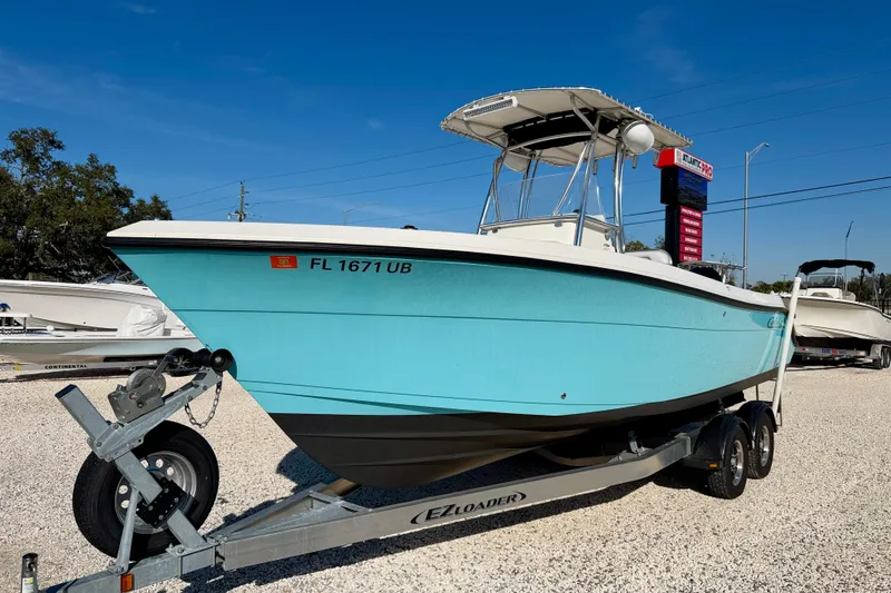 Slide: The Image of 2021 Cobia 237 Center Console boat on trailer, displayed outdoors. - 2