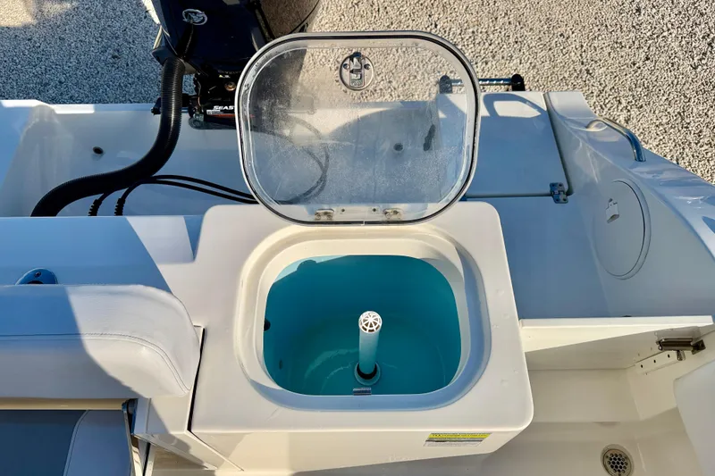 Slide: The Image of 2021 Cobia 237 Center Console boat with open livewell and engine detail. - 23