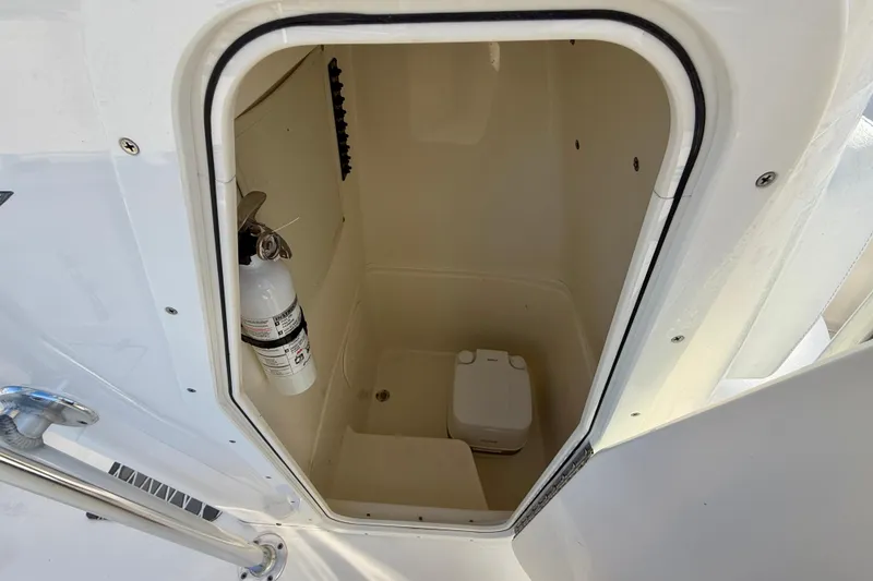 Slide: The Image of 2021 Cobia 237 Center Console boat interior with fire extinguisher and portable toilet. - 25