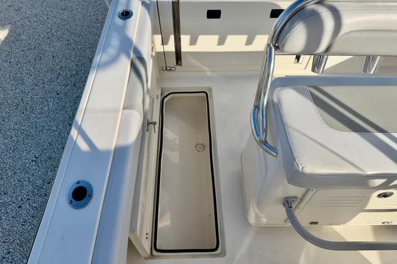 Slide: The Image of 2021 Cobia 237 Center Console boat interior with seating and storage compartment. - 26