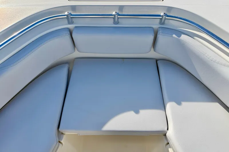 Slide: The Image of 2021 Cobia 237 Center Console boat seating area with cushioned seats and stainless steel railing. - 29