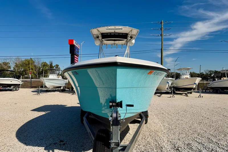 Slide: The Image of 2021 Cobia 237 Center Console boat on display in a sunny outdoor showroom. - 3