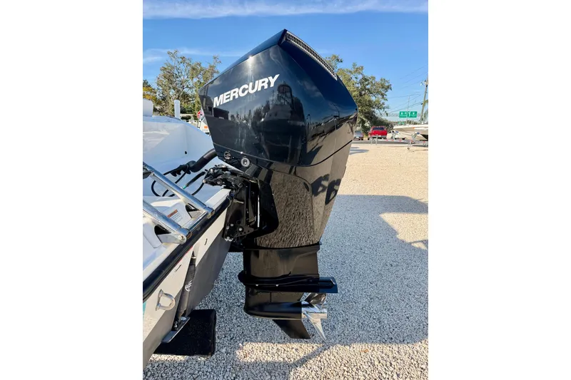 Slide: The Image of 2021 Cobia 237 Center Console with Mercury outboard engine, parked on gravel. - 34
