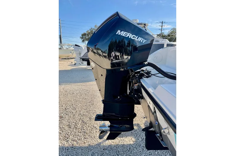 Slide: The Image of 2021 Cobia 237 Center Console with Mercury outboard engine, parked on gravel. - 36